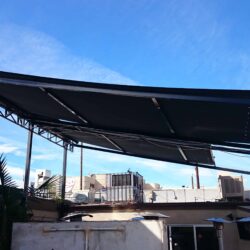 a balcony with black retractable awning - custom awnings - custom awnings near me - custom awnings for decks - custom awnings for business - custom door awnings near me - spear awnings - aluminum awnings - dome awnings
