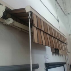 stripe retractable awning installed on a wall - custom awnings - custom awnings near me - custom awnings for decks - custom awnings for business - custom door awnings near me - spear awnings - aluminum awnings - dome awnings