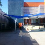 outdoor space with a blue sail shade - custom awnings - custom awnings near me - custom awnings for decks - custom awnings for business - custom door awnings near me - spear awnings - aluminum awnings - dome awnings