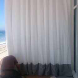 a man with tools installing drapes - custom awnings - custom awnings near me - custom awnings for decks - custom awnings for business - custom door awnings near me - spear awnings - aluminum awnings - dome awnings