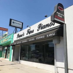 Pierre's Fine Pianos with black storefront awnings - custom awnings - custom awnings near me - custom awnings for decks - custom awnings for business - custom door awnings near me - spear awnings - aluminum awnings - dome awnings