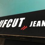 "rufcut jeans" sign laid on a table - custom awnings - custom awnings near me - custom awnings for decks - custom awnings for business - custom door awnings near me - spear awnings - aluminum awnings - dome awnings