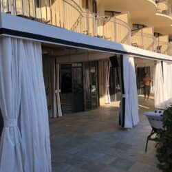 yellow building with a white cabana outside - custom awnings - custom awnings near me - custom awnings for decks - custom awnings for business - custom door awnings near me - spear awnings - aluminum awnings - dome awnings