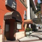 orange building with two entrance canopies - custom awnings - custom awnings near me - custom awnings for decks - custom awnings for business - custom door awnings near me - spear awnings - aluminum awnings - dome awnings