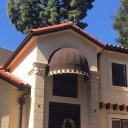 yellow house with a brown dome awning for window - custom awnings - custom awnings near me - custom awnings for decks - custom awnings for business - custom door awnings near me - spear awnings - aluminum awnings - dome awnings