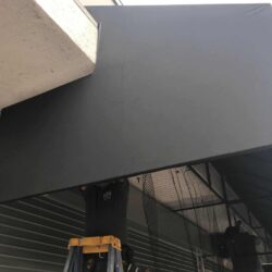 two men installing a black awning for a store - custom awnings - custom awnings near me - custom awnings for decks - custom awnings for business - custom door awnings near me - spear awnings - aluminum awnings - dome awnings