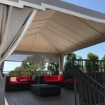 large white cabanas for a home's balcony with sofas and table - concave awnings - aluminum awnings - carports - store front awnings - patio shades