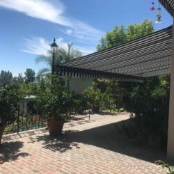 house with stripe awnings for its balcony - custom awnings - custom awnings near me - custom awnings for decks - custom awnings for business - custom door awnings near me - spear awnings - aluminum awnings - dome awnings