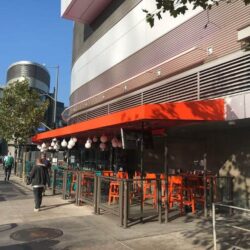 orange awnings for a restaurant with ball shaped lights hanging - concave awnings - aluminum awnings - carports - store front awnings - patio shades
