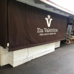 a bar with brown drapes and sign - custom awnings - custom awnings near me - custom awnings for decks - custom awnings for business - custom door awnings near me - spear awnings - aluminum awnings - dome awnings