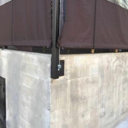 restaurant with brown awnings and drapes with plants decoration - custom awnings - custom awnings near me - custom awnings for decks - custom awnings for business - custom door awnings near me - spear awnings - aluminum awnings - dome awnings