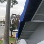a white house with blue awnings - custom awnings - custom awnings near me - custom awnings for decks - custom awnings for business - custom door awnings near me - spear awnings - aluminum awnings - dome awnings