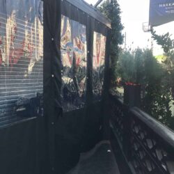 restaurant with black drapes for its balcony seating - custom awnings - custom awnings near me - custom awnings for decks - custom awnings for business - custom door awnings near me - spear awnings - aluminum awnings - dome awnings