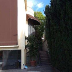 yellow house with pool and brown awnings for window - custom awnings - custom awnings near me - custom awnings for decks - custom awnings for business - custom door awnings near me - spear awnings - aluminum awnings - dome awnings