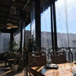 a restaurant with balcony seating with drapes - custom awnings - custom awnings near me - custom awnings for decks - custom awnings for business - custom door awnings near me - spear awnings - aluminum awnings - dome awnings