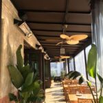 a restaurant with balcony seating with drapes - custom awnings - custom awnings near me - custom awnings for decks - custom awnings for business - custom door awnings near me - spear awnings - aluminum awnings - dome awnings