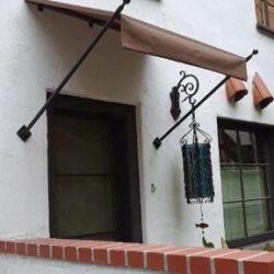 a white house with a spear awning for its front door - custom awnings - custom awnings near me - custom awnings for decks - custom awnings for business - custom door awnings near me - spear awnings - aluminum awnings - dome awnings