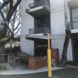 an outdoor store in front of a building with a white sail shade - custom awnings - custom awnings near me - custom awnings for decks - custom awnings for business - custom door awnings near me - spear awnings - aluminum awnings - dome awnings