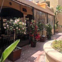 light brown awnings with drapes for a yellow home - custom awnings - custom awnings near me - custom awnings for decks - custom awnings for business - custom door awnings near me - spear awnings - aluminum awnings - dome awnings