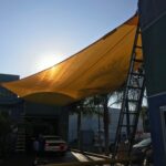 outdoor space with yellow sail shade - custom awnings - custom awnings near me - custom awnings for decks - custom awnings for business - custom door awnings near me - spear awnings - aluminum awnings - dome awnings