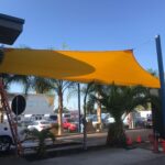 outdoor space with yellow sail shade - custom awnings - custom awnings near me - custom awnings for decks - custom awnings for business - custom door awnings near me - spear awnings - aluminum awnings - dome awnings