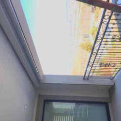 white roller shade for a balcony with a pool in the background - roller shade installation - roller shade ideas - roller shade indoor - roller shade near me - spear awnings - dome awnings - retractable awning company - roller shade cost
