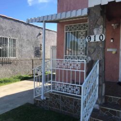 white aluminum awnings for a red bungalow house with a small front deck and white staircase railings - aluminum awnings - aluminum awnings near me - aluminum awnings for decks - aluminum awnings cost - aluminum awnings companies near me - retractable awnings - roll ups curtains