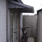 glass door with a bike in front and aluminium awning - custom awnings - custom awnings near me - custom awnings for decks - custom awnings for business - custom door awnings near me - spear awnings - aluminium awnings - dome awnings