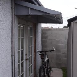 glass door with a bike in front and aluminium awning - custom awnings - custom awnings near me - custom awnings for decks - custom awnings for business - custom door awnings near me - spear awnings - aluminium awnings - dome awnings
