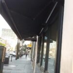 maroon retractable awnings for a glass sliding window - commercial restaurant awnings - custom commercial awnings - custom commercial awnings near me - custom business awnings - patio awnings - window awnings benefits - drapes - cabanas