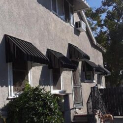 house with black window awnings - custom awnings - custom awnings near me - custom awnings for decks - custom awnings for business - custom door awnings near me - spear awnings - aluminum awnings - dome awnings