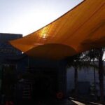 outdoor space with orange sail shade - custom awnings - custom awnings near me - custom awnings for decks - custom awnings for business - custom door awnings near me - spear awnings - aluminum awnings - dome awnings