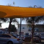 car parking with yellow sail shade - custom awnings - custom awnings near me - custom awnings for decks - custom awnings for business - custom door awnings near me - spear awnings - aluminum awnings - dome awnings