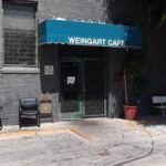 Weingart cafe with a blue storefront awning - custom awnings - custom awnings near me - custom awnings for decks - custom awnings for business - custom door awnings near me - spear awnings - aluminum awnings - dome awnings