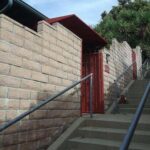 an apartment with a red gate - custom awnings - custom awnings near me - custom awnings for decks - custom awnings for business - custom door awnings near me - spear awnings - aluminum awnings - dome awnings