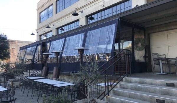 empty restaurant with black drapes for its balcony seating - custom awnings - custom awnings near me - custom awnings for decks - custom awnings for business - custom door awnings near me - spear awnings - aluminum awnings - dome awnings
