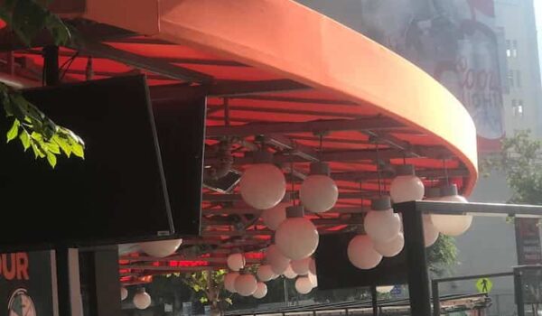 orange awnings for a restaurant with ball shaped lights hanging - concave awnings - aluminum awnings - carports - store front awnings - patio shades