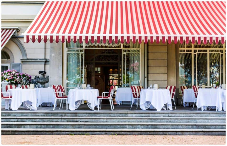 A restaurant with red and white striped awnings.