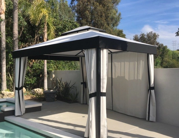 A black and white cabana in los angeles next to a pool.