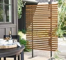A patio with a table and chairs enhanced with a wooden outdoor privacy screen