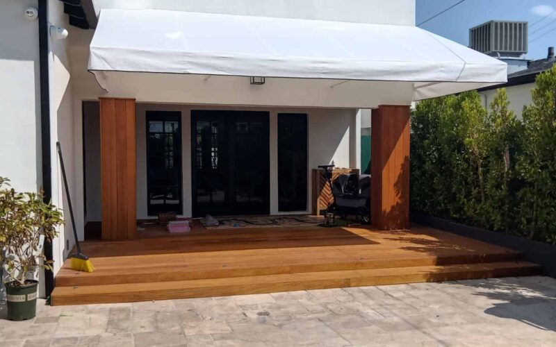 IMG_20250910_165313 A patio featuring a white awning and a wooden deck, creating a cozy outdoor space for relaxation.